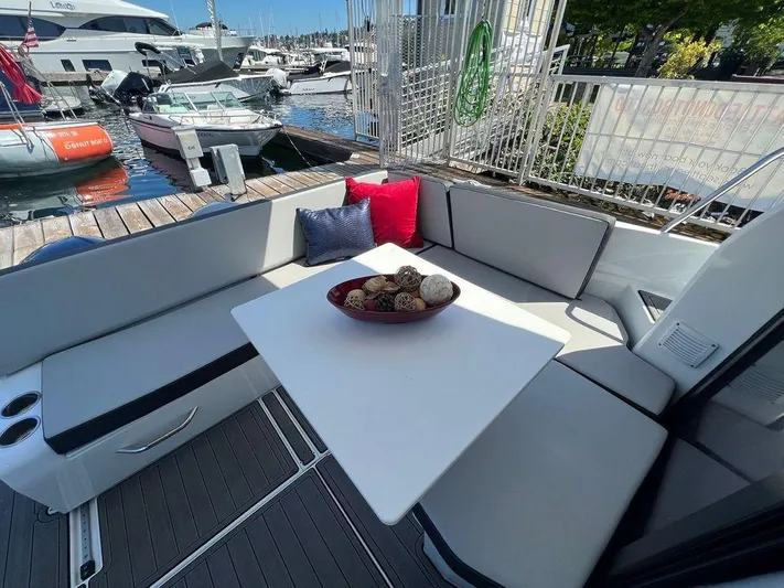 Yacht Photos Pics Jeanneau 895 2021 boat with outdoor seating area and table at marina.