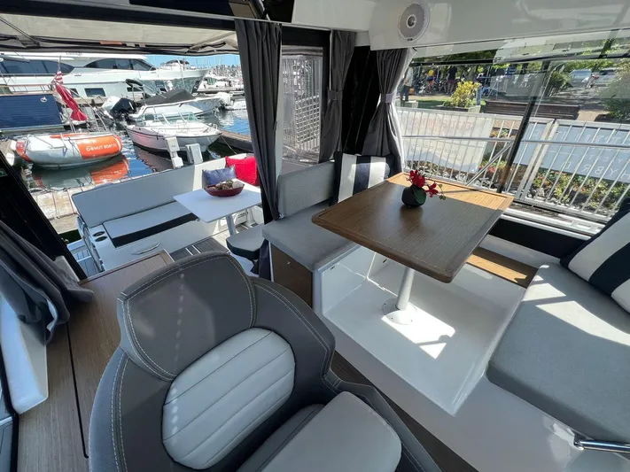  Yacht Photos Pics Interior of 2021 Jeanneau 895 boat with dining area and marina view.