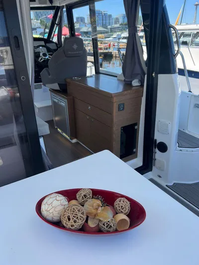  Yacht Photos Pics Interior view of 2021 Jeanneau 895 boat with decorative bowl on table.