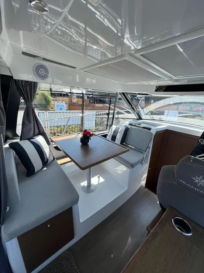  Yacht Photos Pics Interior of 2021 Jeanneau 895 boat with dining area and helm station.