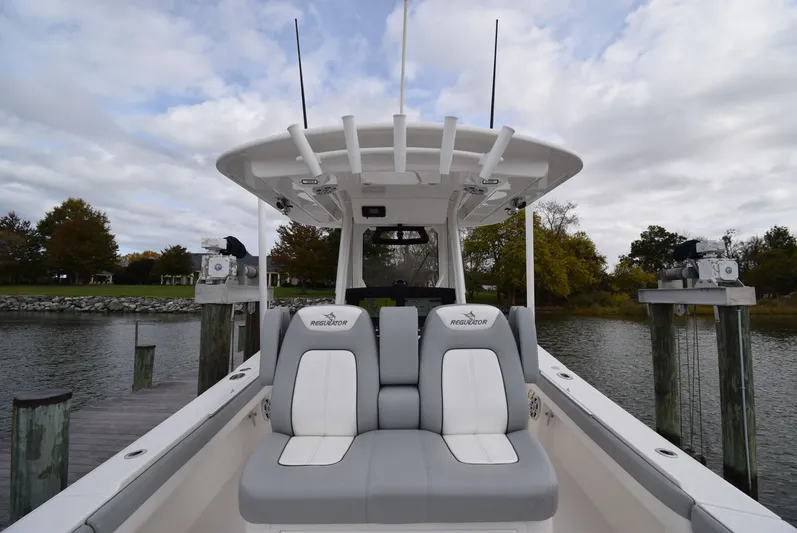 Shore Runner Yacht Photos Pics 2021 Regulator 34 boat with dual seats docked by a scenic waterfront.