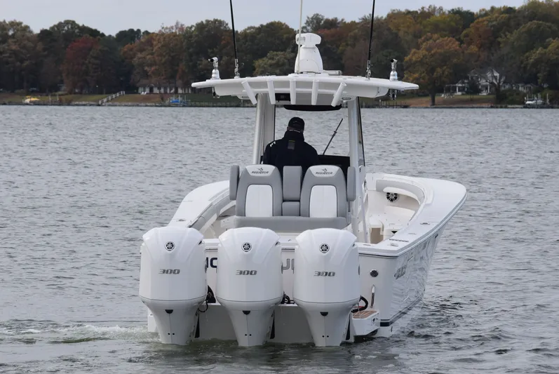 Shore Runner Yacht Photos Pics 2021 Regulator 34 boat with triple 300 horsepower engines on a calm lake.