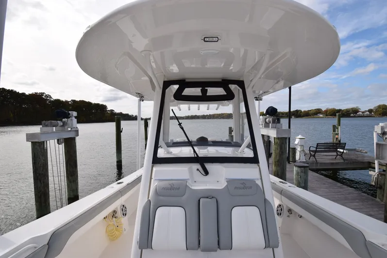 Shore Runner Yacht Photos Pics 2021 Regulator 34 boat docked by a serene waterfront.