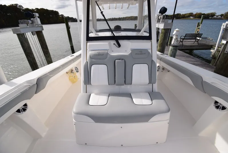 Shore Runner Yacht Photos Pics 2021 Regulator 34 boat interior with cushioned seating, docked by a serene waterfront.