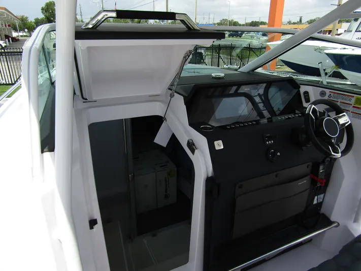  Yacht Photos Pics 2024 Axopar 37 Sun Top boat interior with modern helm and open cabin door.