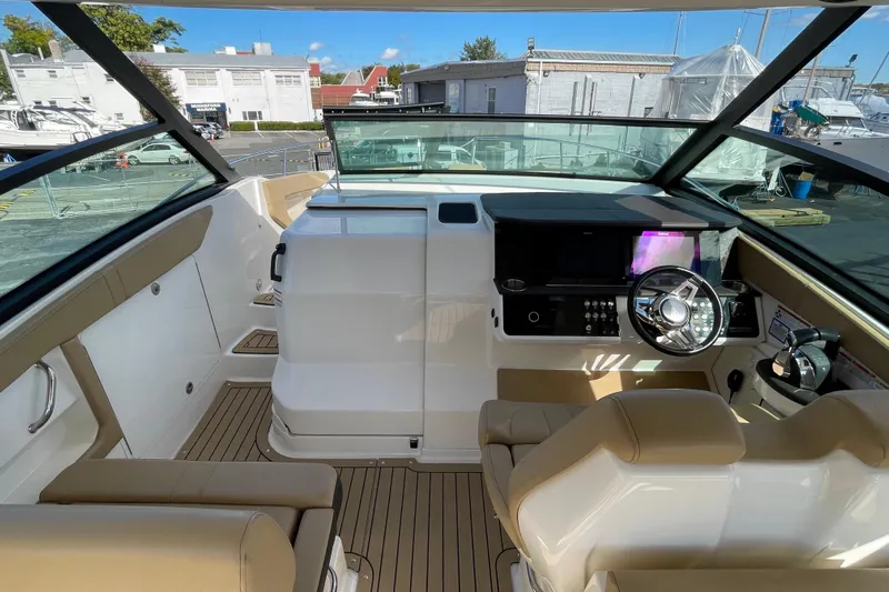  Yacht Photos Pics 2020 Sea Ray Sundancer 320 cockpit with modern helm, beige seating, and marina view.
