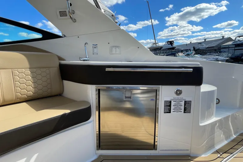  Yacht Photos Pics 2020 Sea Ray Sundancer 320 interior with seating and kitchenette under blue sky.