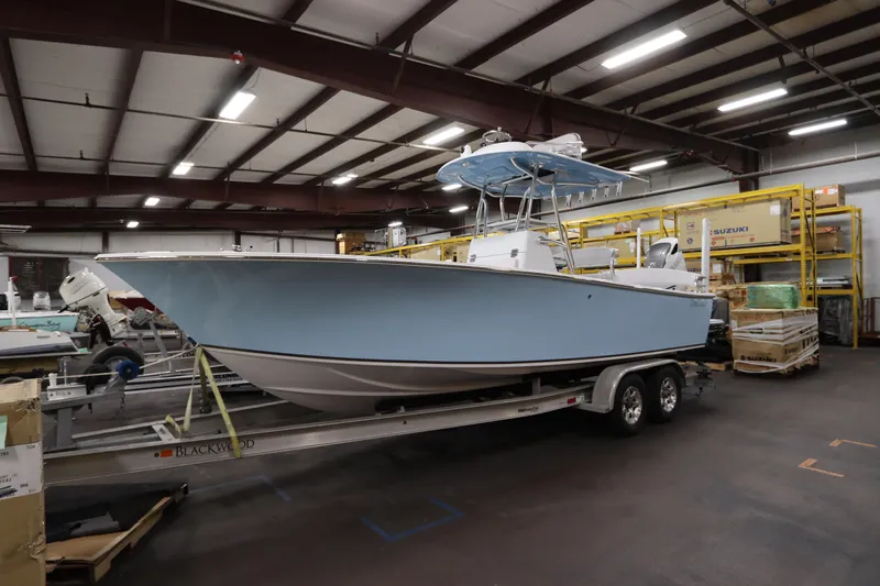  Yacht Photos Pics 2024 SeaCraft 23CC boat in warehouse, light blue hull on trailer.