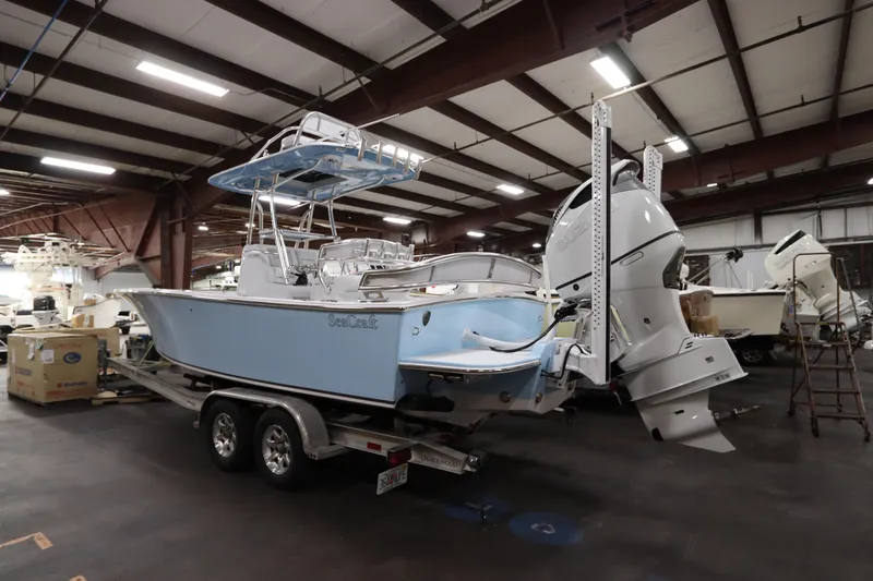  Yacht Photos Pics 2024 SeaCraft 23CC boat in a warehouse, featuring dual outboard motors.