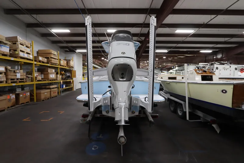  Yacht Photos Pics 2024 SeaCraft 23CC boat in warehouse, rear view with motor and storage shelves.