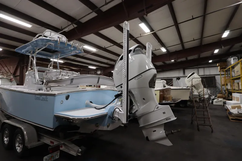  Yacht Photos Pics 2024 SeaCraft 23CC boat in warehouse, featuring dual outboard motors.