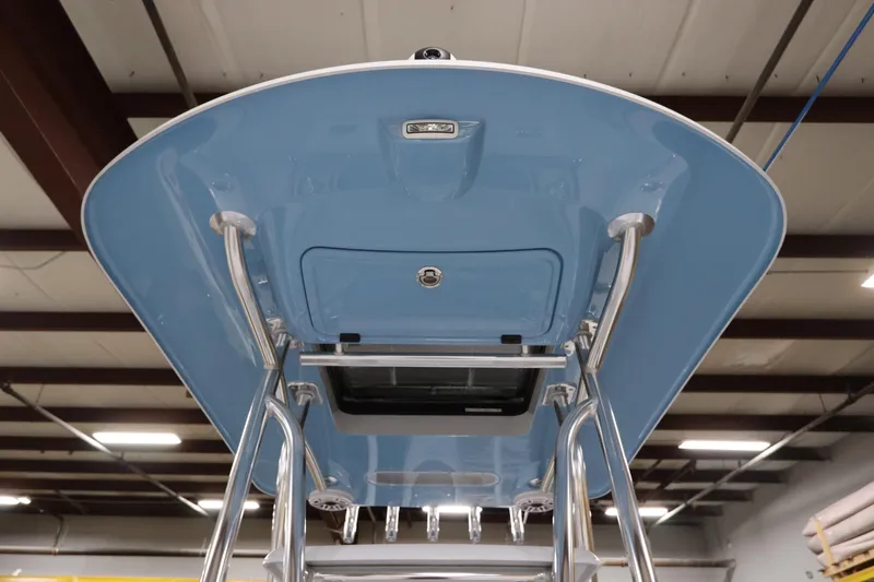  Yacht Photos Pics 2024 SeaCraft 23CC boat's blue T-top with stainless steel supports in a warehouse.