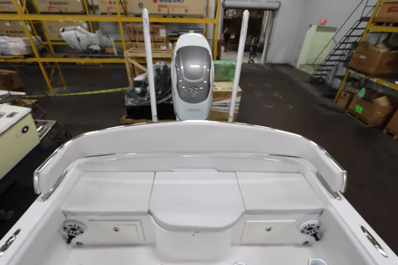  Yacht Photos Pics 2024 SeaCraft 23CC boat interior with storage compartments and speakers in a warehouse setting.