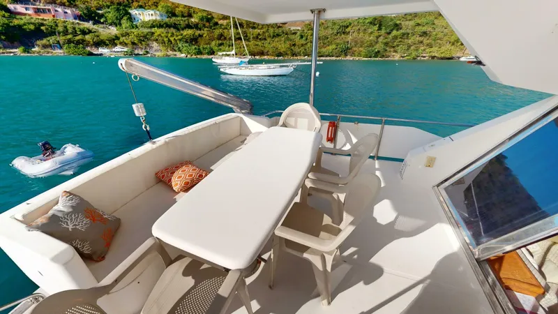 Aurora Of St.vincent Yacht Photos Pics Luxurious Horizon 48 yacht deck with seating, table, and scenic ocean view, year 2000 model.