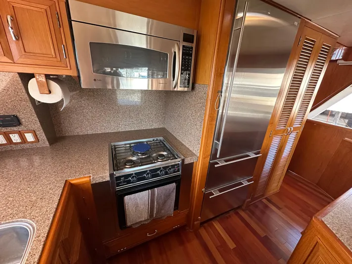  Yacht Photos Pics 1985 Ocean Alexander Pilothouse kitchen with stainless steel appliances and wooden cabinetry.