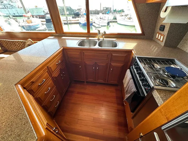  Yacht Photos Pics 1985 Ocean Alexander Pilothouse kitchen with wood cabinets, dual sink, and gas stove, overlooking marina.
