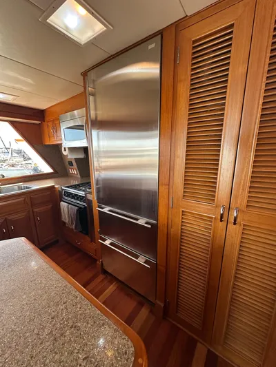  Yacht Photos Pics 1985 Ocean Alexander Pilothouse kitchen with stainless steel appliances and wooden cabinetry.
