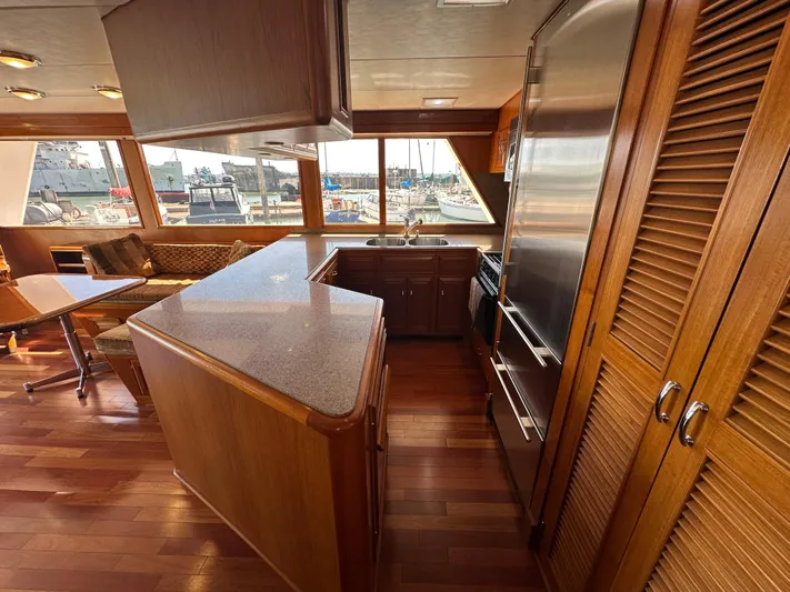  Yacht Photos Pics Luxurious 1985 Ocean Alexander Pilothouse interior with wood finishes and marina view.