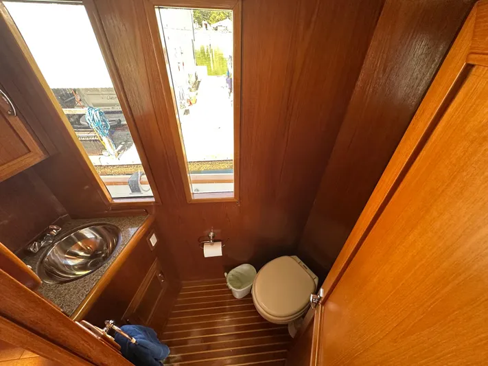  Yacht Photos Pics 1985 Ocean Alexander Pilothouse bathroom with wooden interior, sink, and toilet.