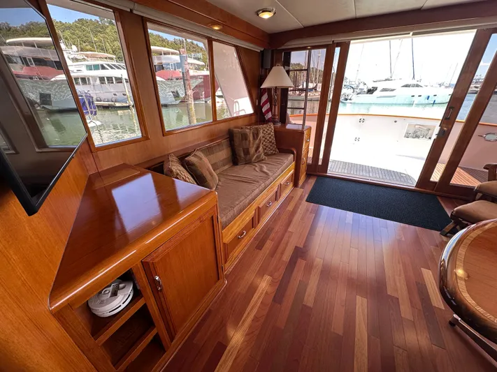  Yacht Photos Pics Luxurious 1985 Ocean Alexander Pilothouse interior with wooden flooring and marina view.