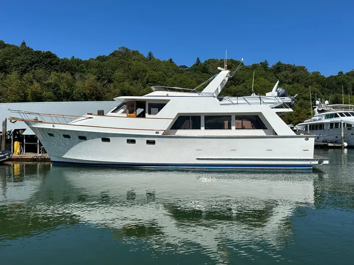  Yacht Photos Pics 1985 Ocean Alexander Pilothouse yacht docked in a serene marina setting.
