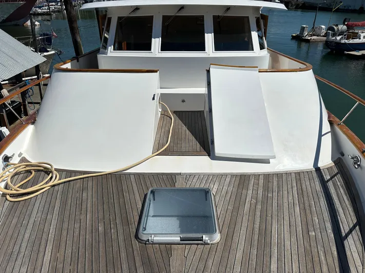  Yacht Photos Pics 1985 Ocean Alexander Pilothouse yacht deck with wooden flooring and white structures.