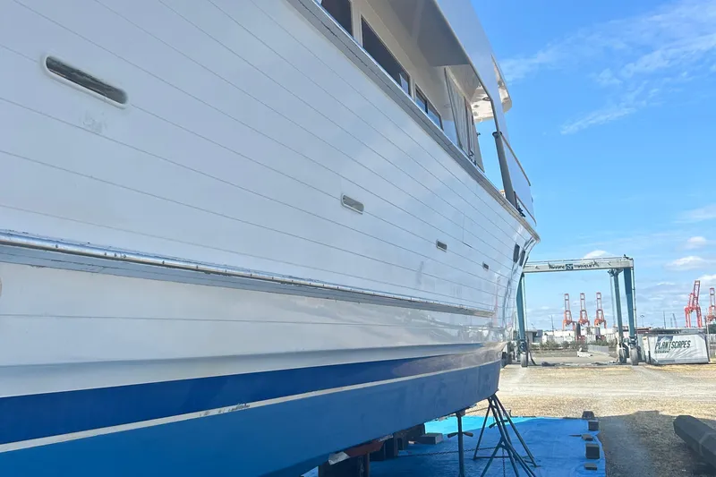  Yacht Photos Pics 1985 Ocean Alexander Pilothouse yacht on dry dock, side view with blue sky background.