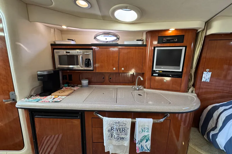  Yacht Photos Pics 2007 Sea Ray 340 Sundancer interior kitchen with microwave, sink, and TV.