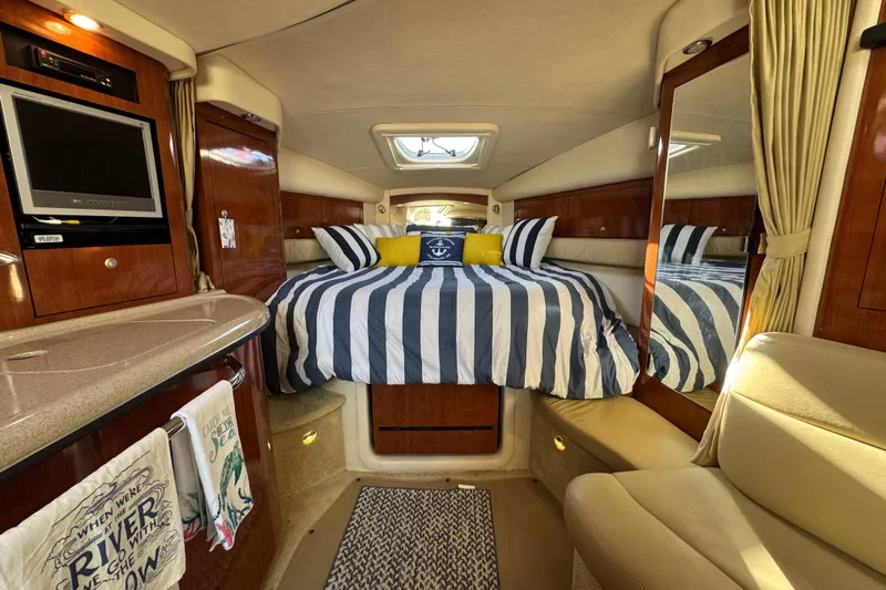  Yacht Photos Pics Luxurious interior of 2007 Sea Ray 340 Sundancer with striped bedding and elegant wood finishes.