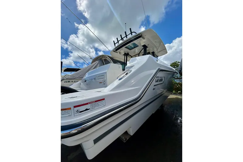  Yacht Photos Pics 2023 Boston Whaler 360 Outrage boat under a bright blue sky with clouds.