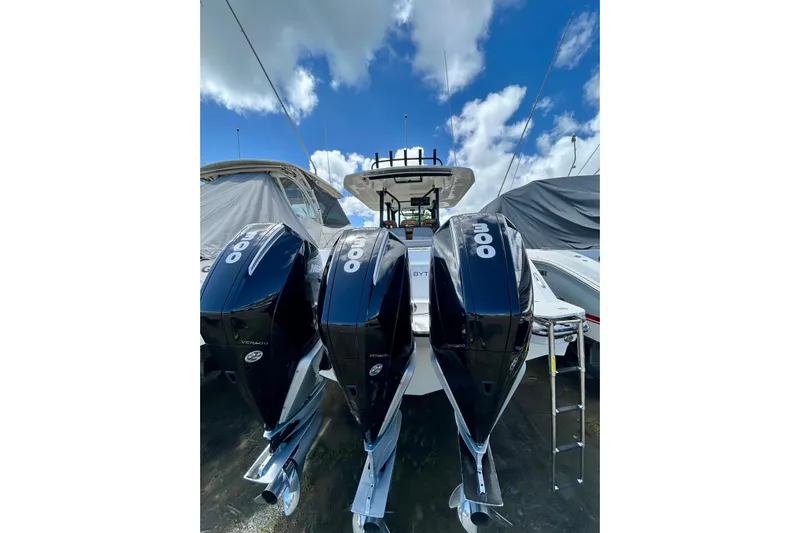  Yacht Photos Pics 2023 Boston Whaler 360 Outrage with triple 300 horsepower engines, docked under a blue sky.