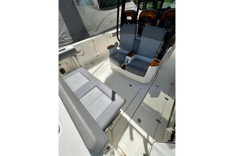  Yacht Photos Pics 2023 Boston Whaler 360 Outrage interior with cushioned seating and sleek design.