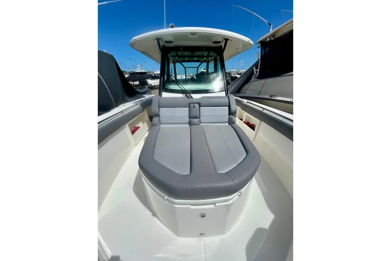  Yacht Photos Pics 2023 Boston Whaler 360 Outrage boat interior with cushioned seating and sleek design.