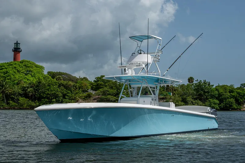 It's Time Yacht Photos Pics 2015 Bahama 41 boat on water near lush greenery and lighthouse.
