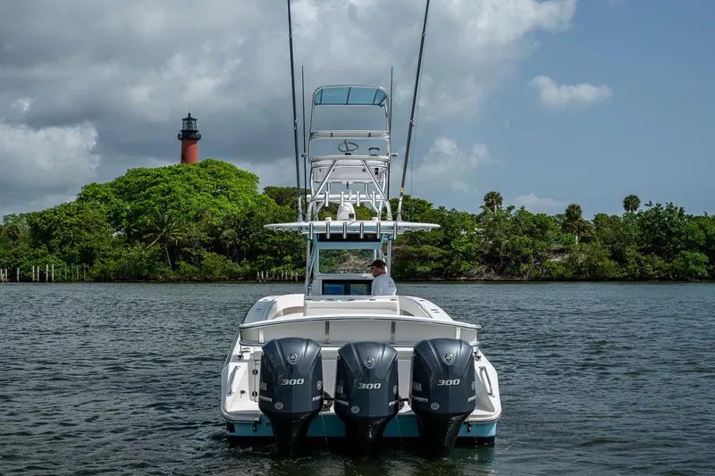 It's Time Yacht Photos Pics 2015 Bahama 41 boat with triple engines on water, lighthouse and greenery in background.