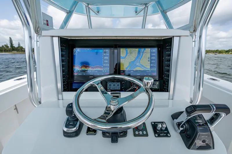 It's Time Yacht Photos Pics Control panel of a 2015 Bahama 41 boat with navigation screens and steering wheel.
