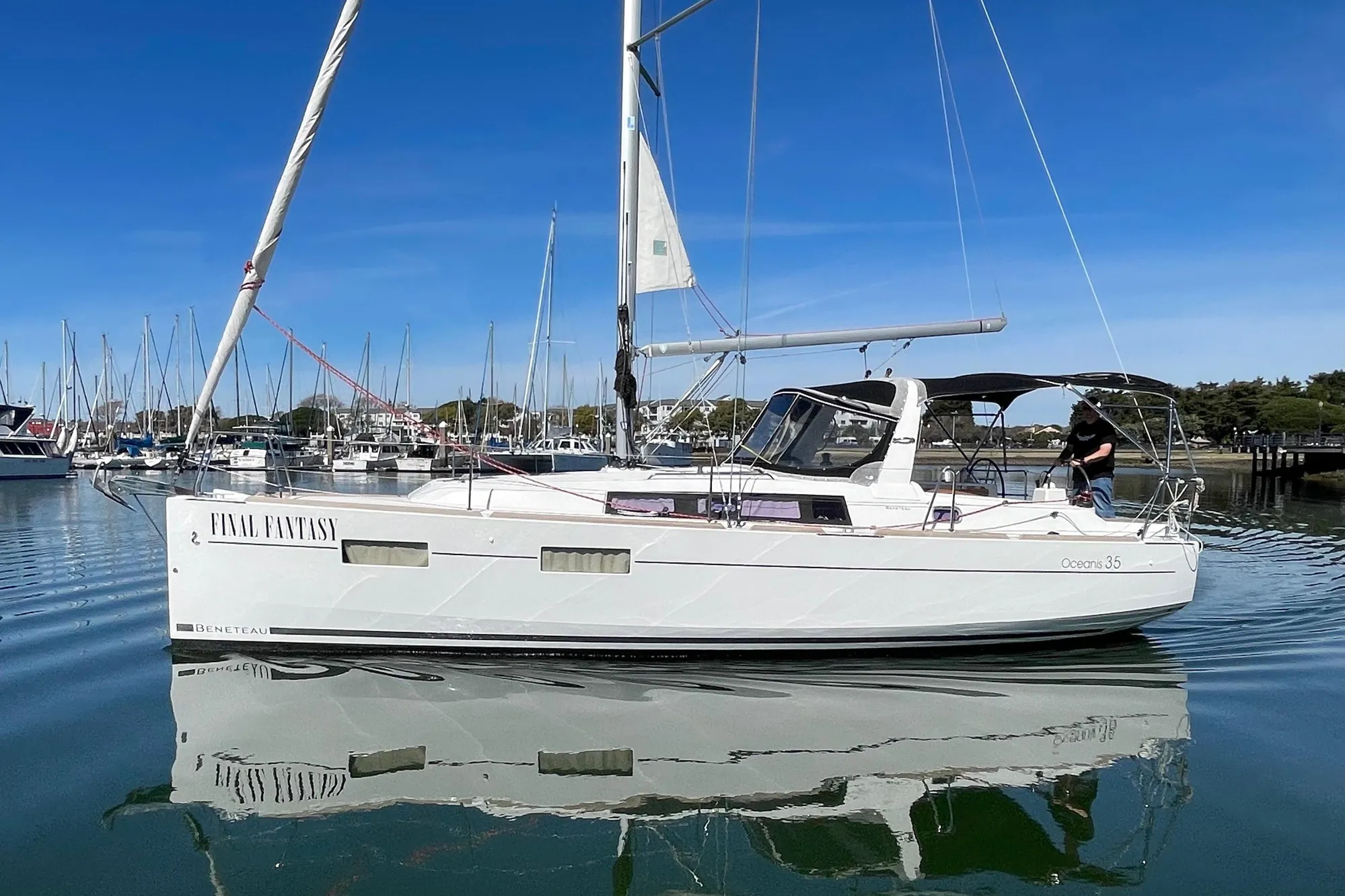 2015 Beneteau First 235 sailboat docked in marina, clear blue sky.