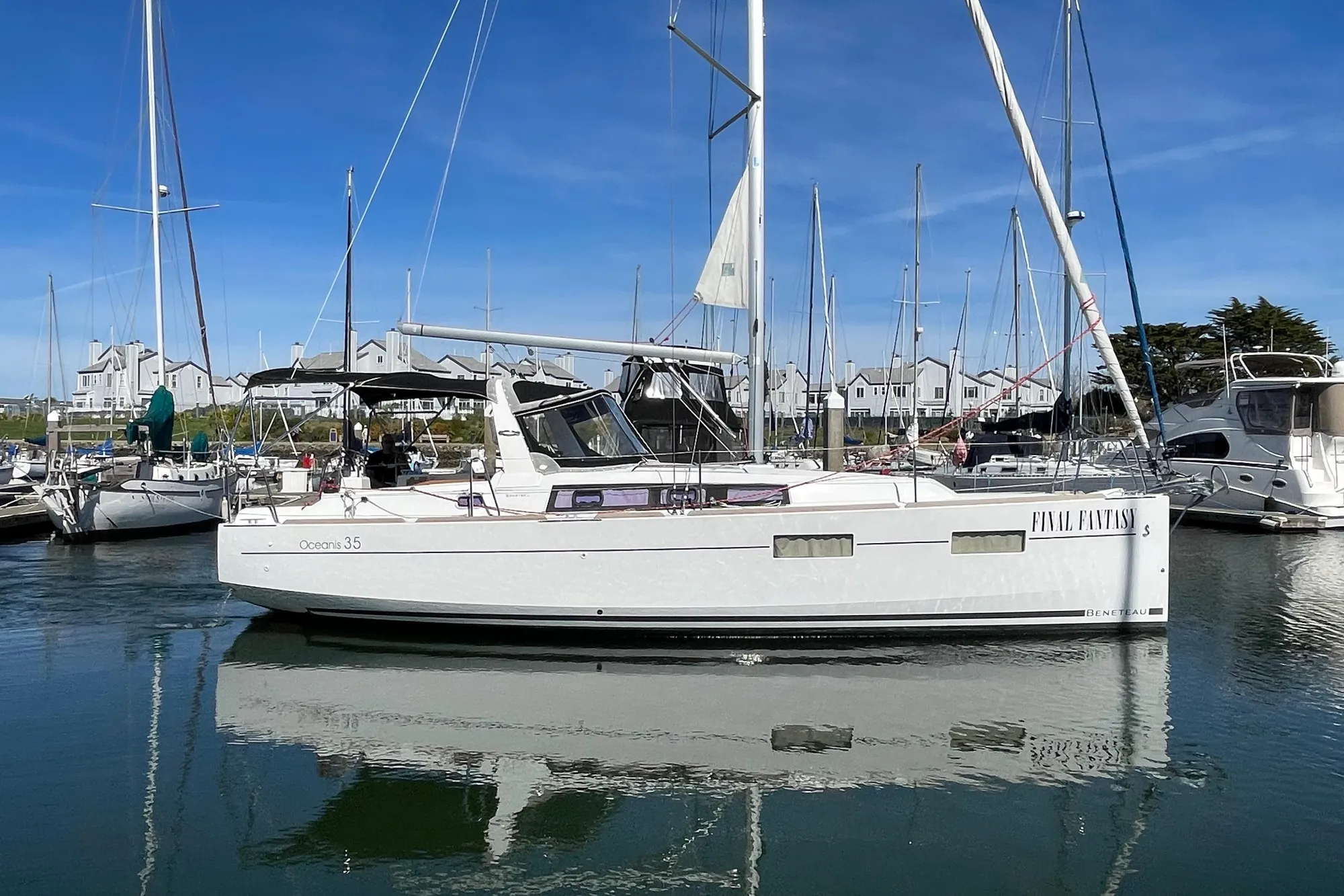 Sailboat docked in marina, Beneteau First 235, 2015 model, clear blue sky.
