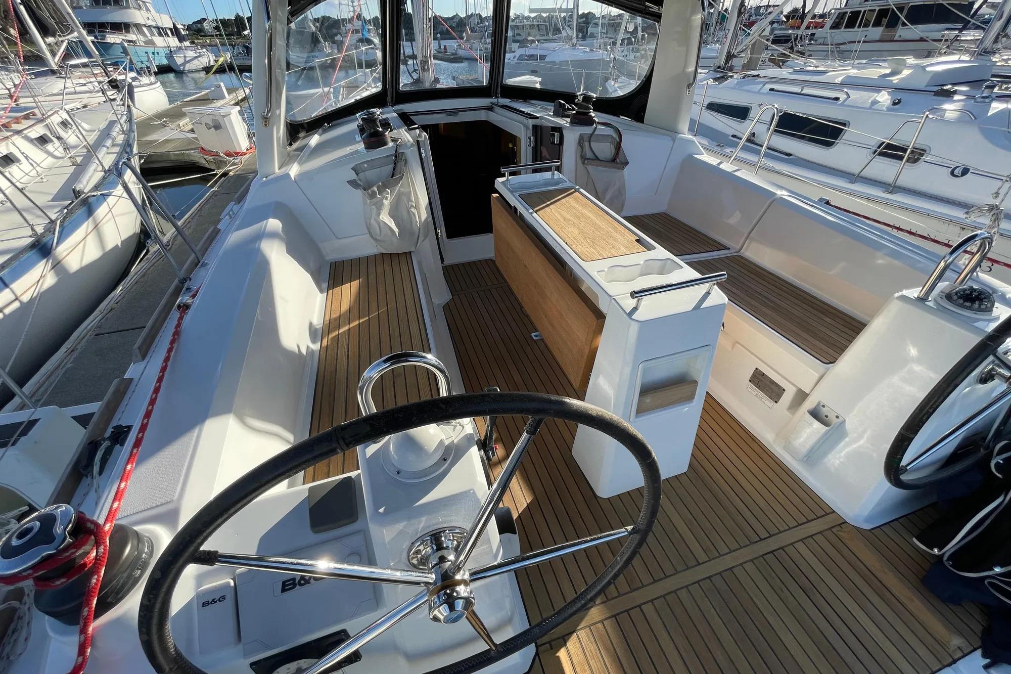 Cockpit of 2015 Beneteau First 235 sailboat with teak flooring and dual steering wheels.