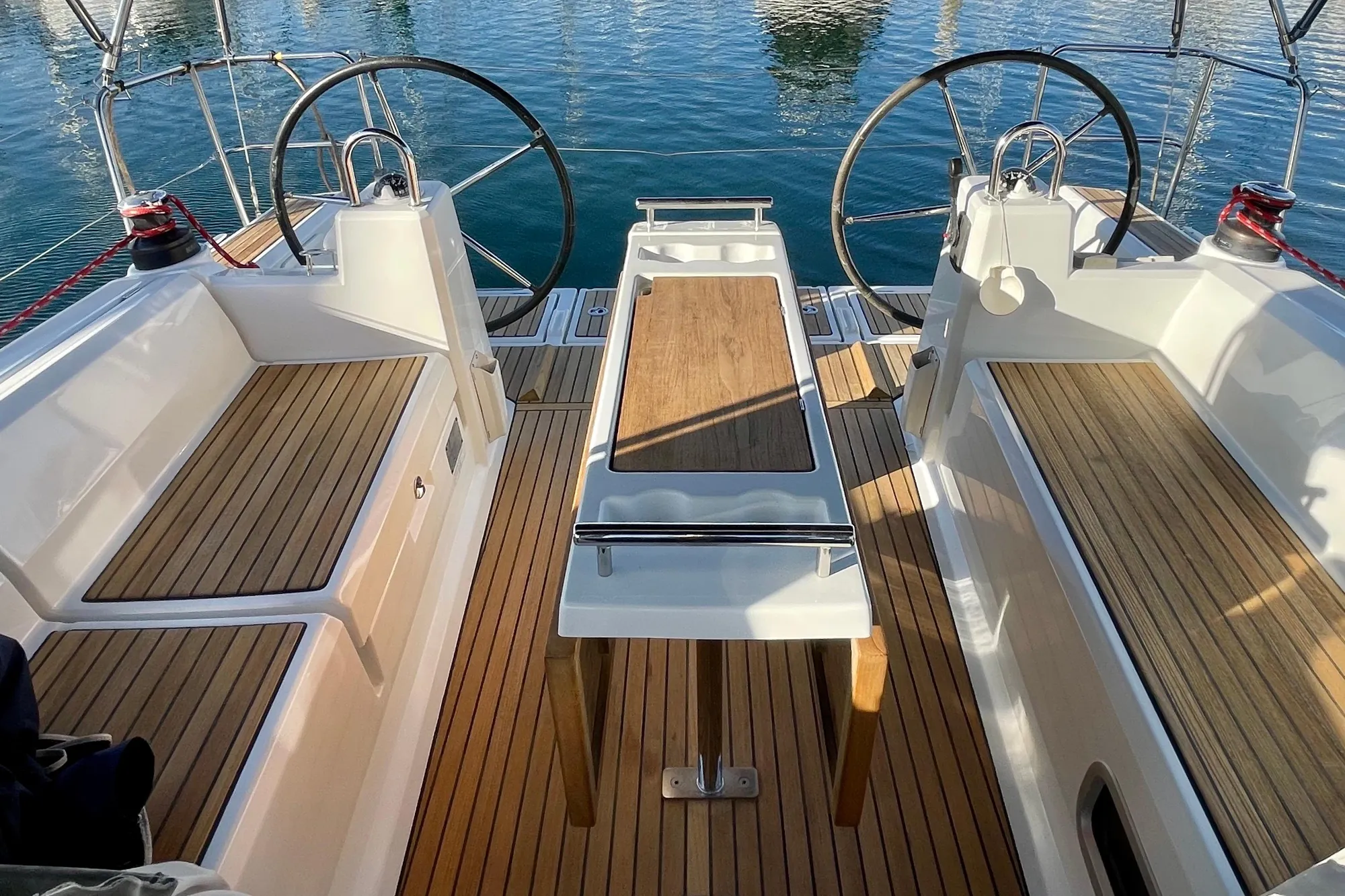 Cockpit of 2015 Beneteau First 235 sailboat with dual steering wheels and wooden seating.