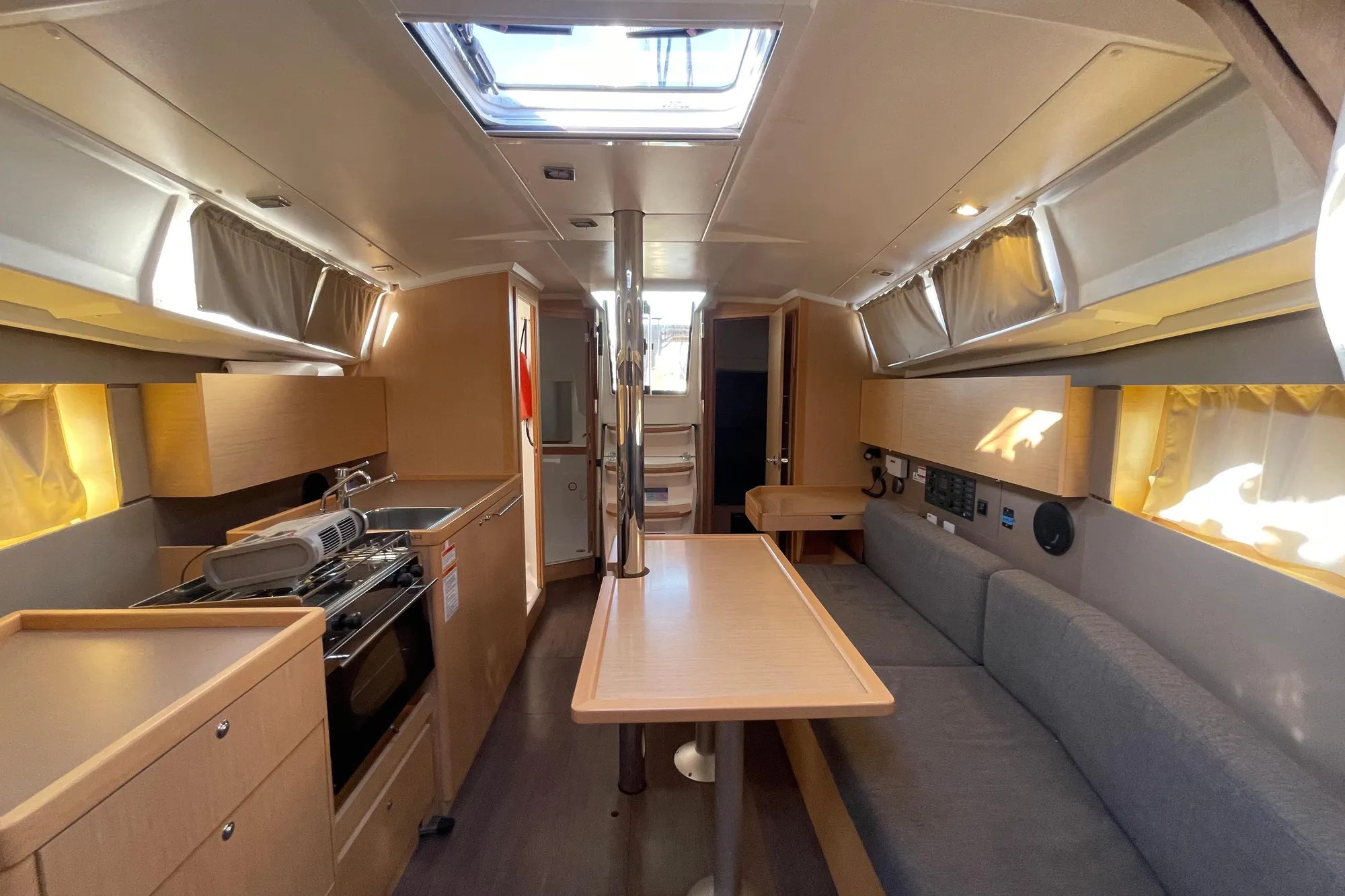 Interior of 2015 Beneteau First 235 sailboat, featuring modern kitchen and seating area.