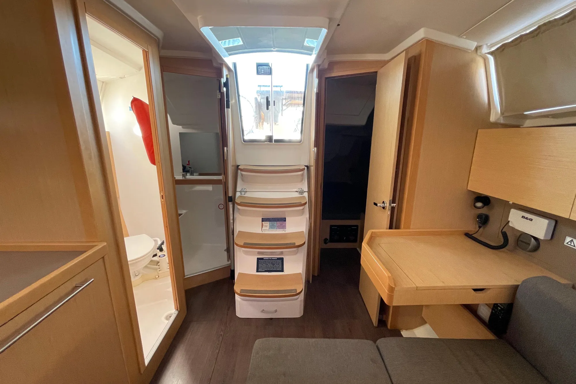 Interior of 2015 Beneteau First 235 sailboat, featuring compact design and wooden furnishings.