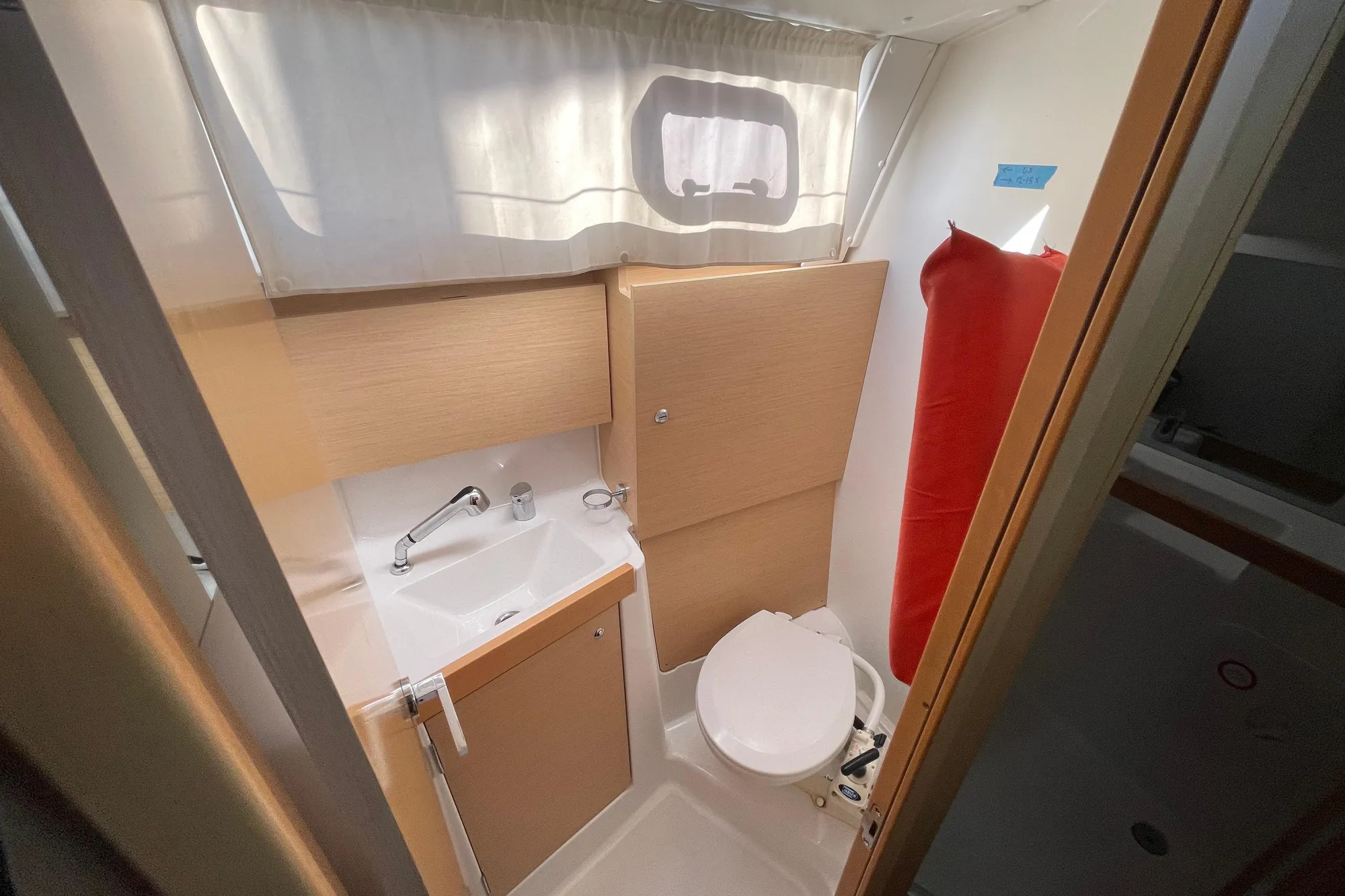 Compact bathroom in 2015 Beneteau First 235 sailboat with sink and toilet.