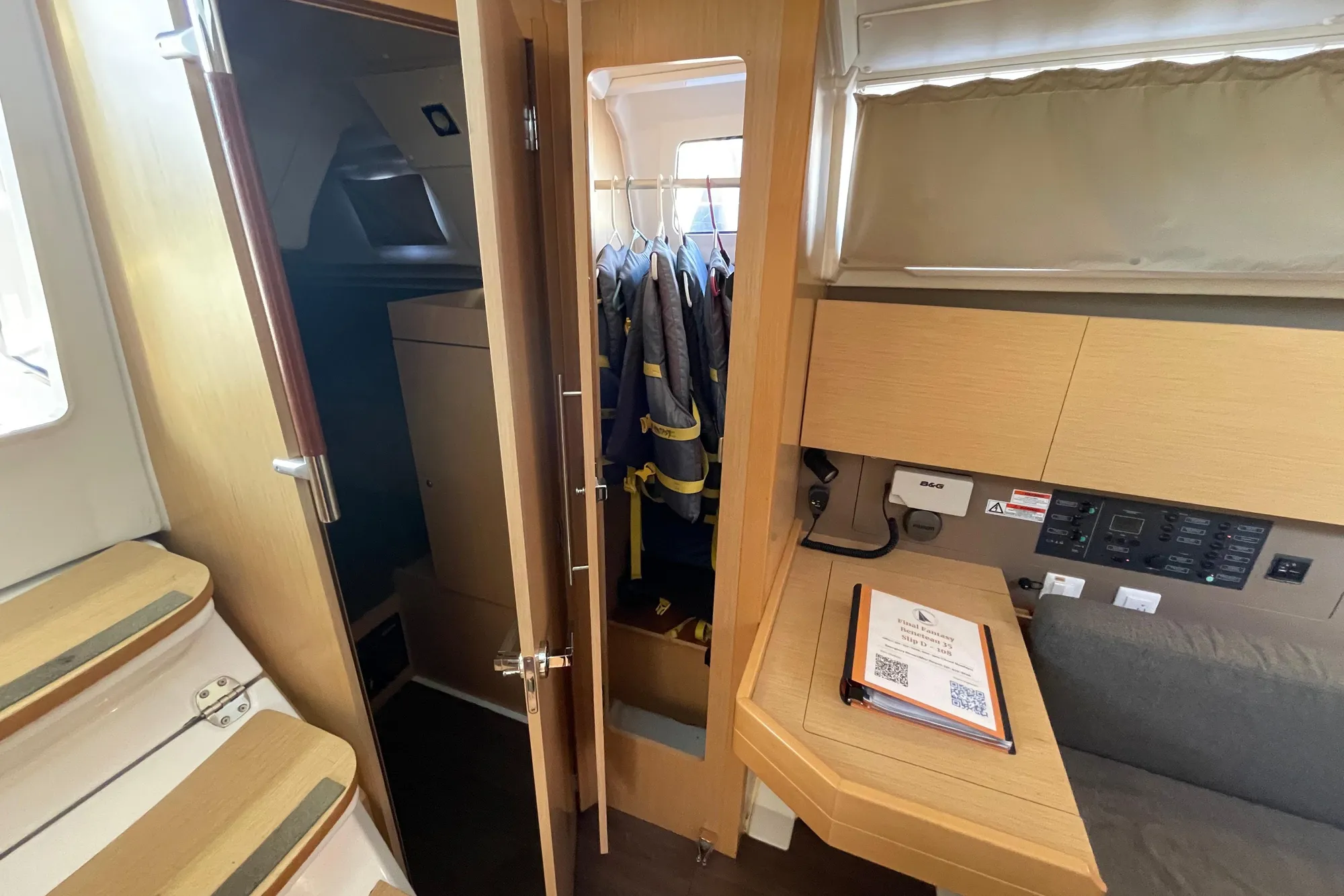 Interior of 2015 Beneteau First 235 sailboat with wooden cabinetry and navigation station.
