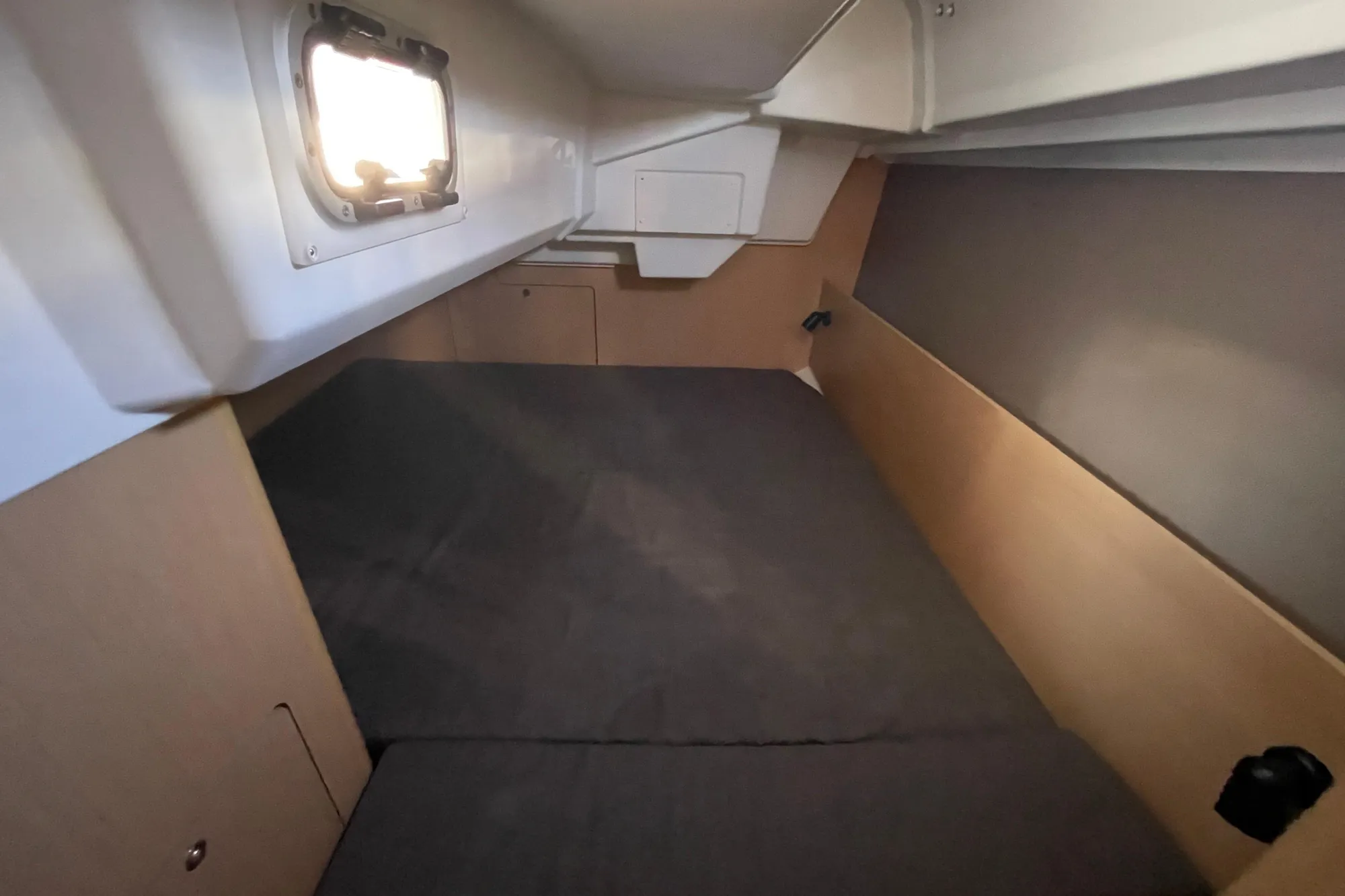 Interior cabin of 2015 Beneteau First 235 sailboat, featuring a cozy sleeping area.
