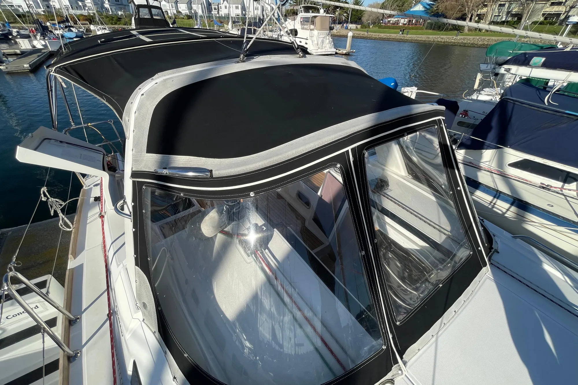 2015 Beneteau First 235 sailboat with black canopy docked at marina.