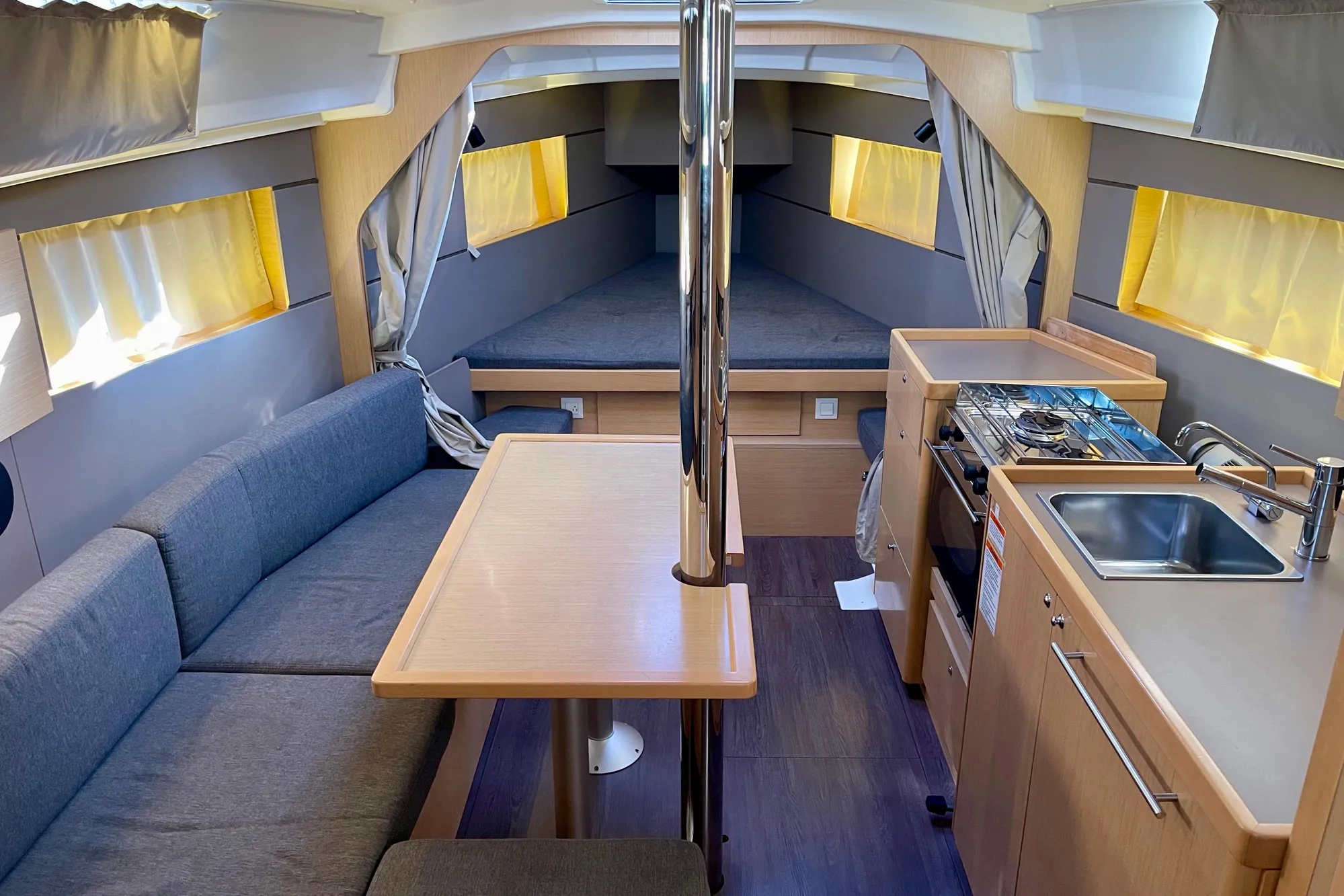 Interior of 2015 Beneteau Oceanis 35 sailboat with cozy seating, kitchenette, and sleeping area.