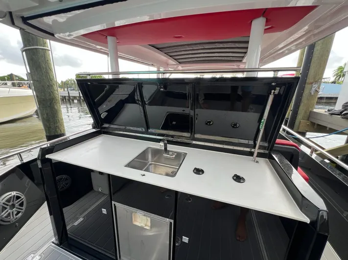  Yacht Photos Pics 2018 Axopar 37 Sun Top boat with outdoor kitchenette and sink.