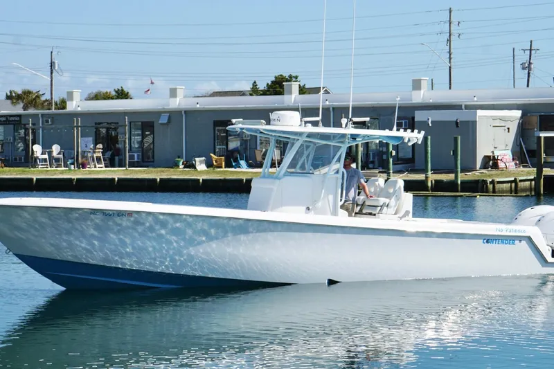  Yacht Photos Pics 2020 Contender 35 ST boat on calm water near a dockside building.