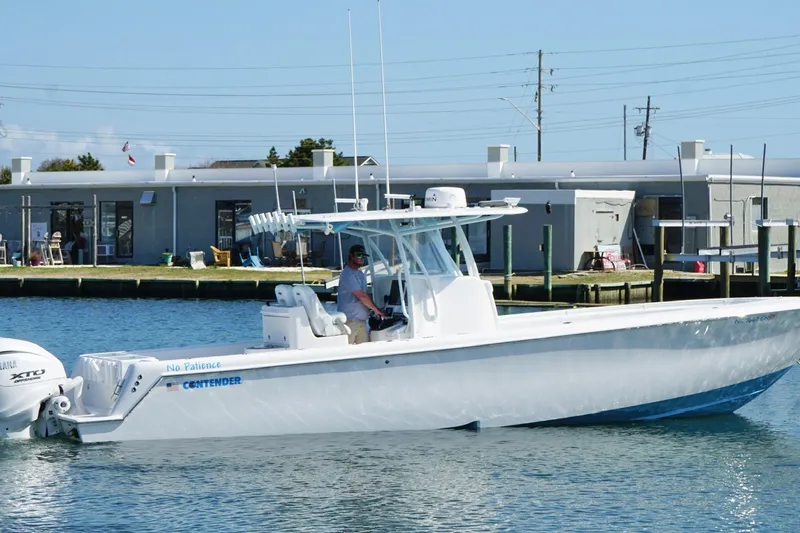  Yacht Photos Pics 2020 Contender 35 ST boat on water near dock, featuring sleek design and powerful engines.